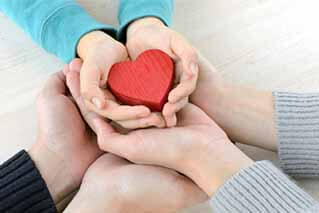 Heart object covered by family members' hands